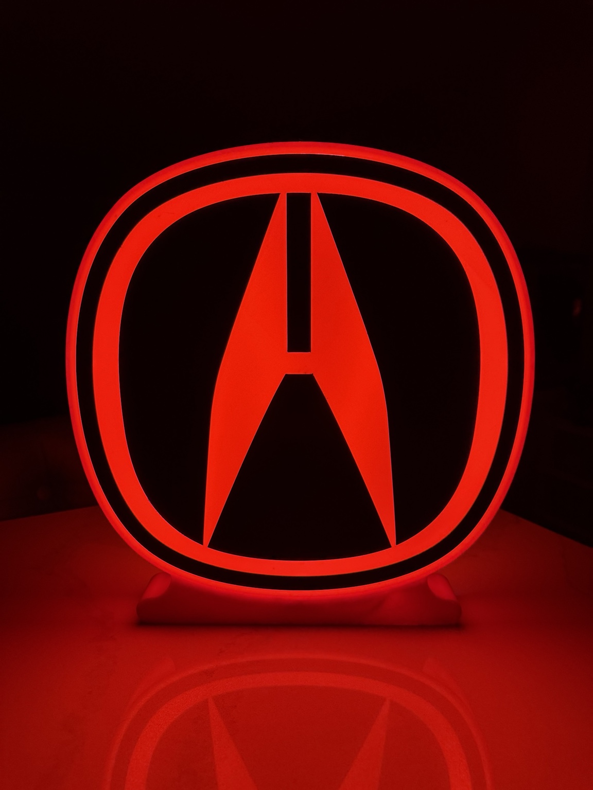 Red Acura symbol illuminated as a circular lightbox