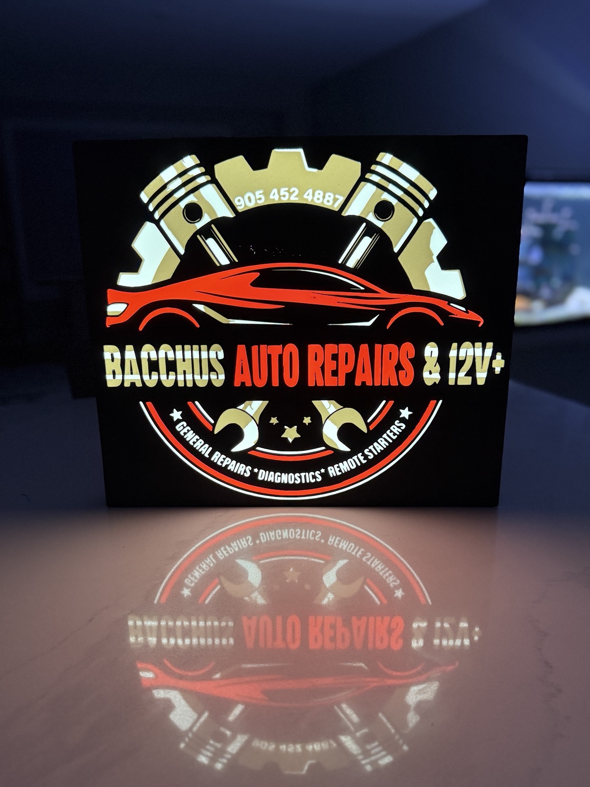 Bacchus Auto Repairs and 12V plus lightbox with red car and engine pistons
