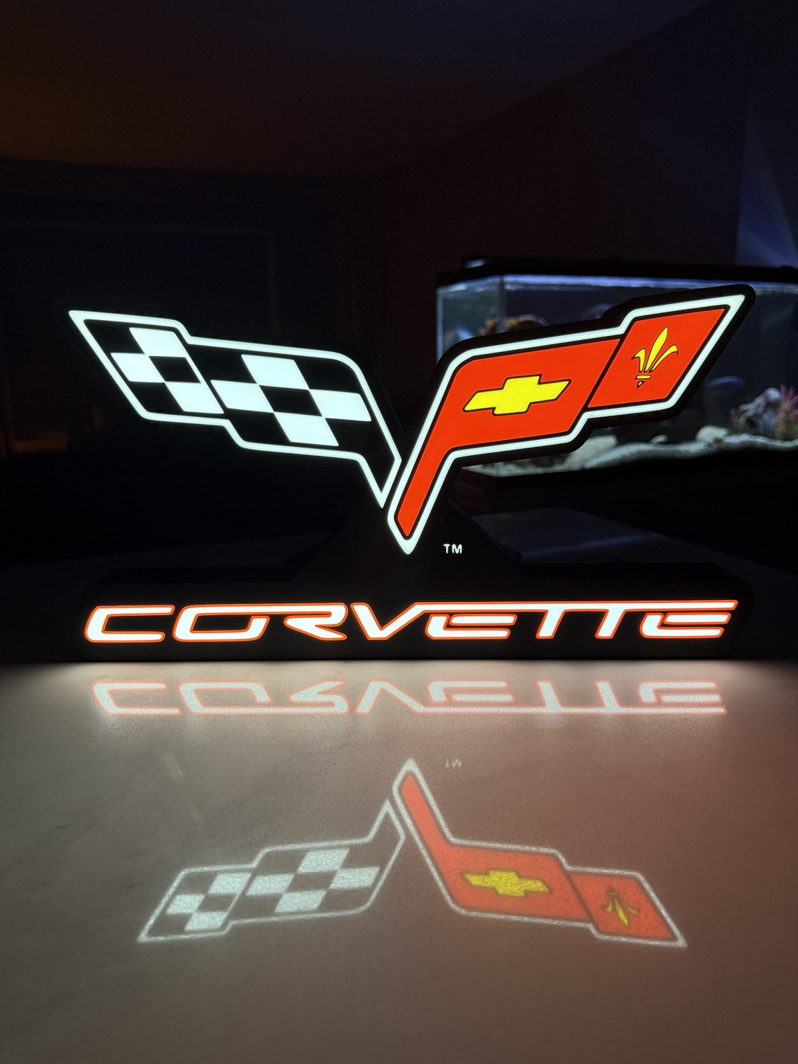 Corvette crossed flags emblem and lettering illuminated in white and red