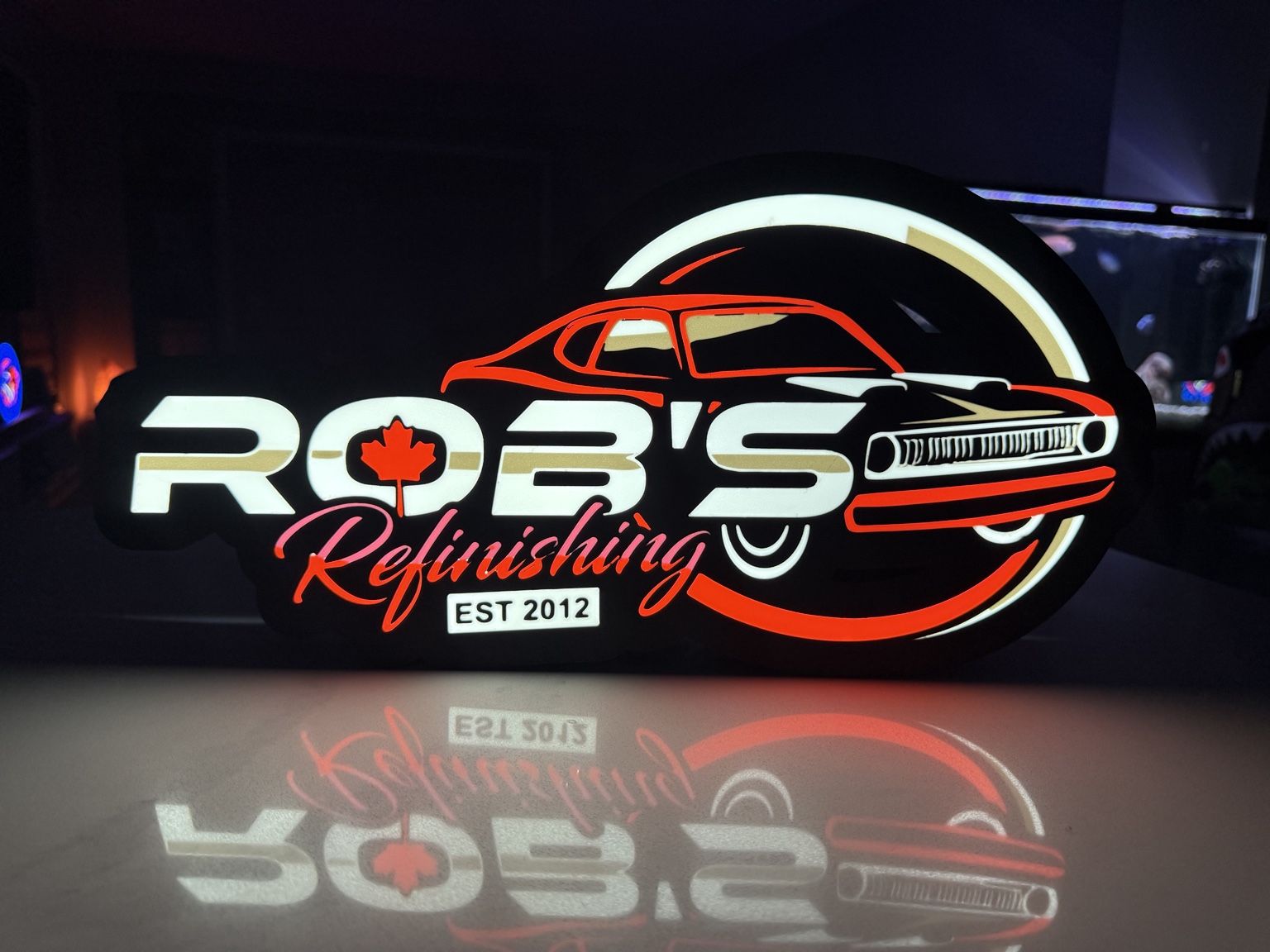 Rob’s Refinishing lightbox with red car outline and maple leaf